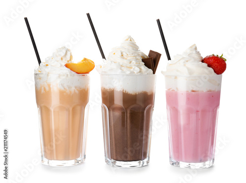 Glasses with delicious milk shakes on white background
