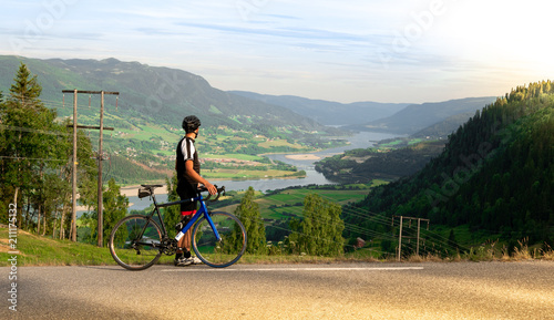 Cyclist with road bike looking at panoramic valley view
