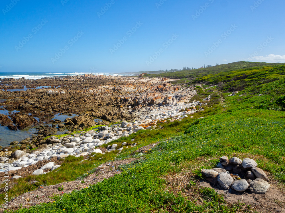 Rocky beach, grass feild with fire place, at ocean, south africa