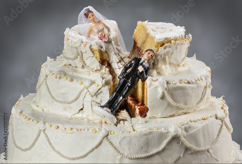 Bride and groom figurines collapsed at ruined wedding cake 