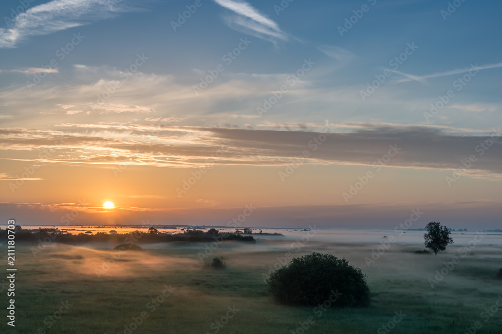 Natural Park of Biebrza Valley - sunrise in foggy morning over medow and pool