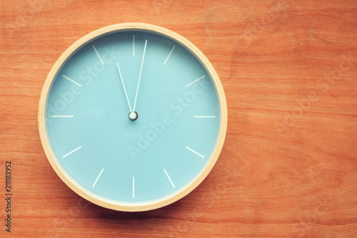 Wall clock on wooden background photo