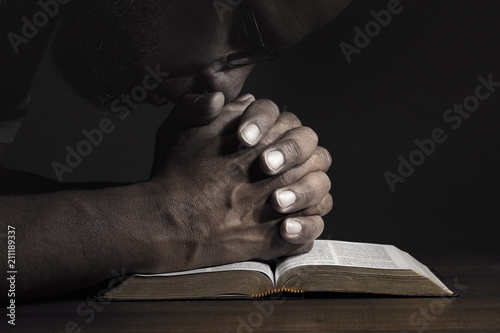 Vászonkép Man praying to God on a Bible