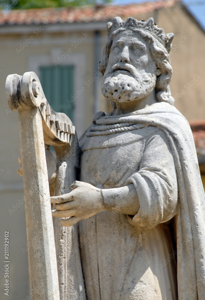 Statue d'un personnage avec une harpe devant la collégiale Saint-Laurent, ville de  Salon de Provence, département des Bouches-du-Rhône, France