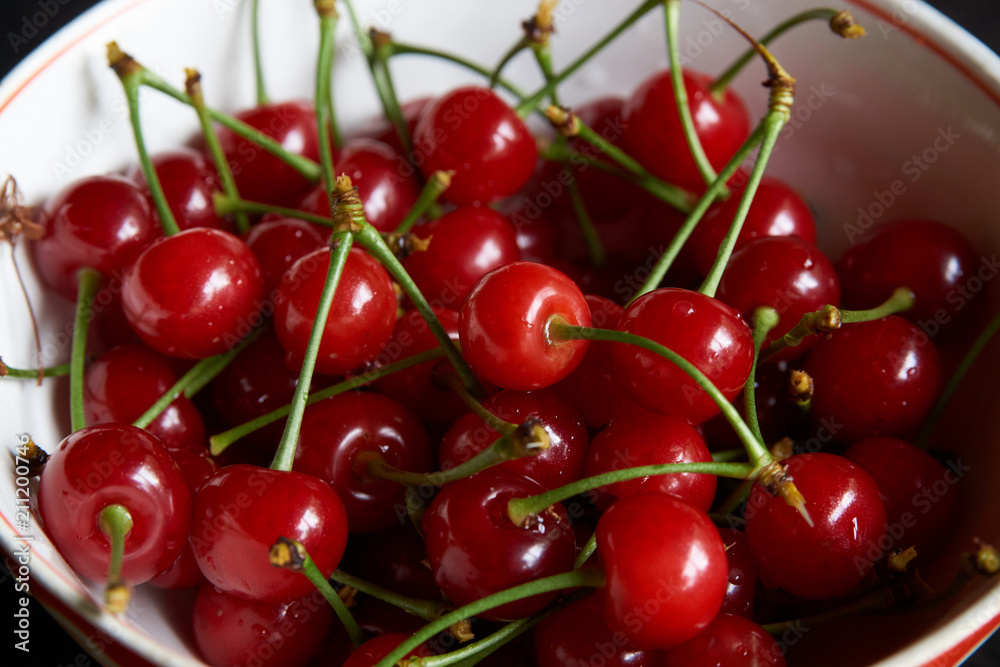Bowl of fresh red cherries on dark background. Raw Red Organic Cherries food, close-up, outdoors Bowl of fresh red cherries on dark background. Raw Red Organic Cherries food, close-up, outdoors