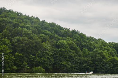 Tourist boat with traveling peoples at green forest and the lake water, beauty in nature. 