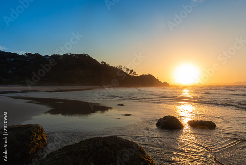 Sunset on the beach with big rocks in Byron Bay, Australia
