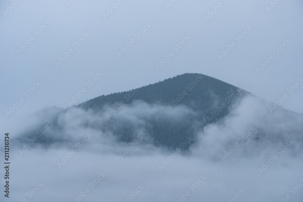 bottom half of the mountain covered in cloud in a misty morning
