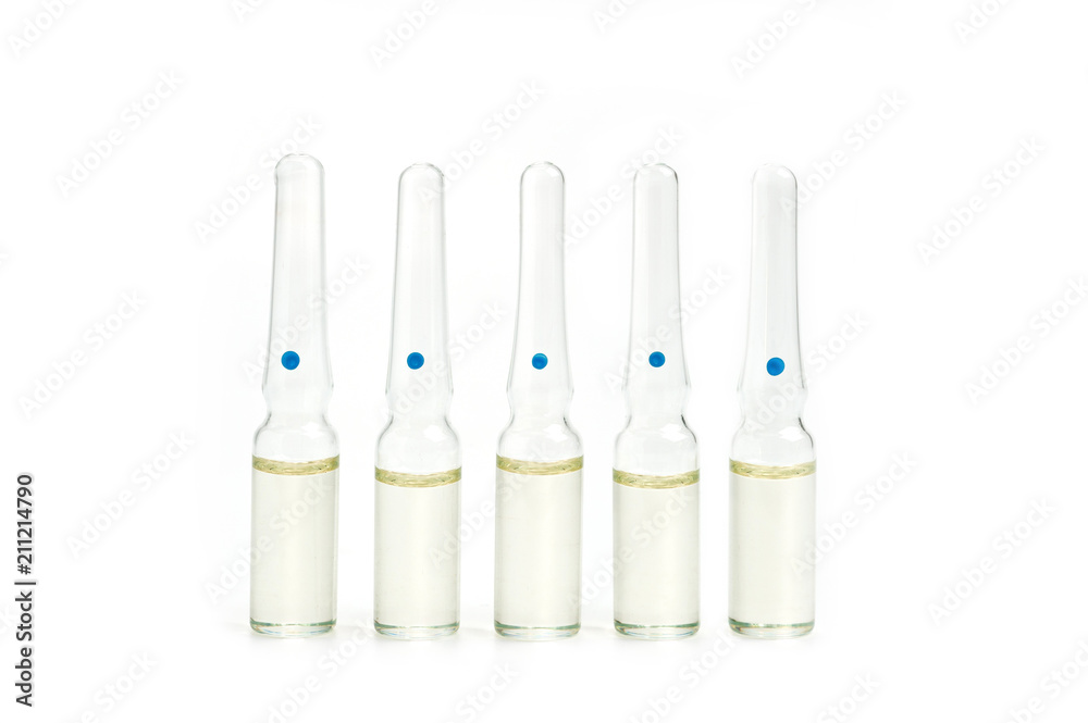 Five glass ampoules with liquid on the old background Five glass ampoules with liquid on the old background