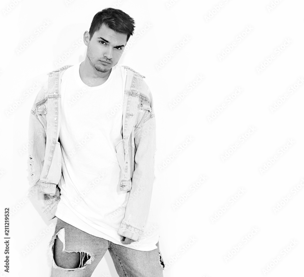 Fototapeta premium Portrait of handsome young model man dressed in jeans clothes posing on white background. Isolated