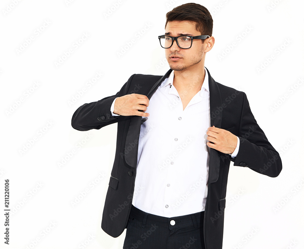 portrait of handsome fashion stylish hipster lumbersexual businessman model dressed in elegant black classic suit posing near white wall in studio. Metrosexual portrait of handsome fashion stylish hipster lumbersexual businessman model dressed in elegant black classic suit posing near white wall in studio. Metrosexual