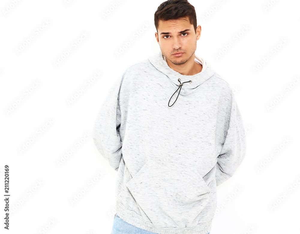 Portrait of young handsome model man dressed in gray casual hoodie clothes posing on white background. Isolated Portrait of young handsome model man dressed in gray casual hoodie clothes posing on white background. Isolated