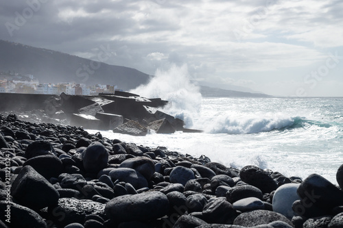 Huge splash on wavebreakers along black lava stone coastline at Puerto de la Cruz, Tenerife, Canary Islands, Spain photo