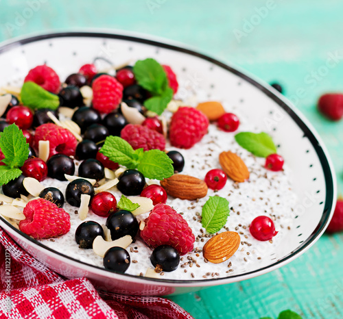 Detox and healthy superfoods breakfast in bowl. Vegan almond milk chia seeds pudding with raspberries, blackberries and mint.