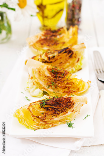 Vegan grilled cabbage steaks on white wooden background. Healthy food.