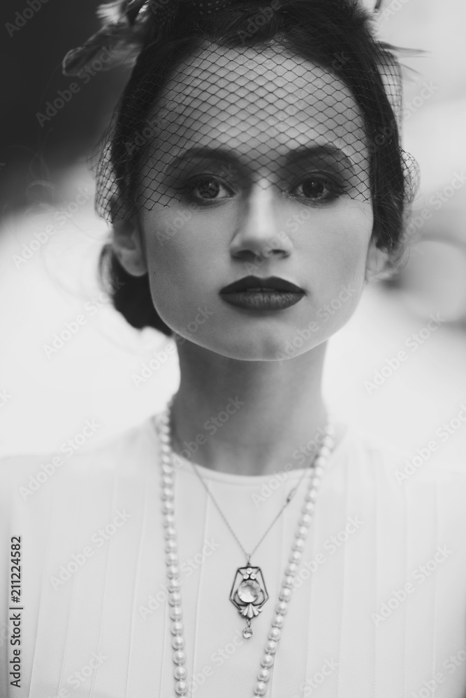 Black and white portrait of a stunning woman dressed in 30s style