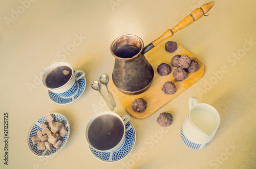 Coffee in a Turkish brewing pot. Home made breakfast. Brown cookies. Enjoy smell of fresh coffee. photo