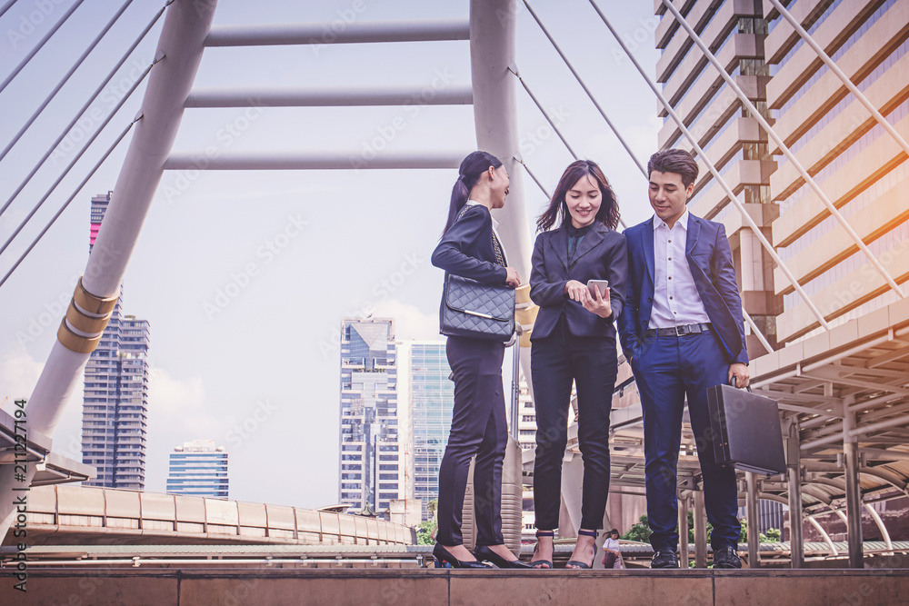 Business team working at city, looking a mobile phone