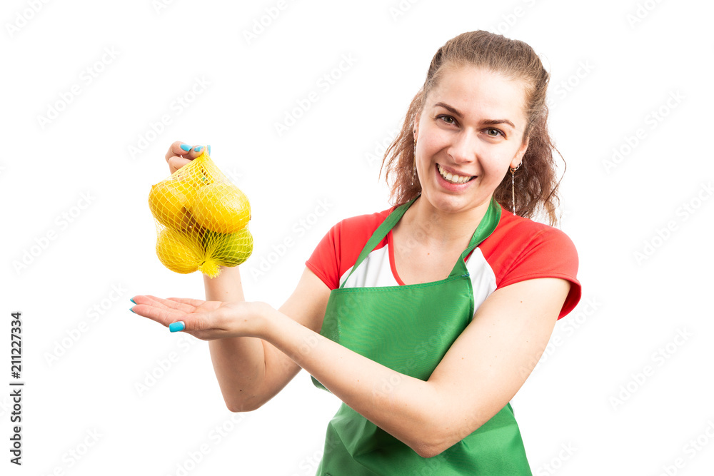 Female supermarket or hypermarket employee presenting lemons . Female supermarket or hypermarket employee presenting lemons .