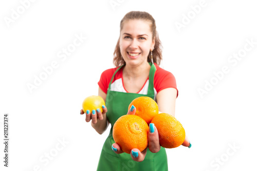 Woman retail of supermarket worker offering tangerines.
