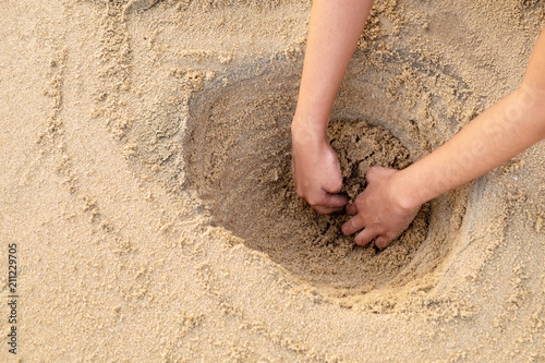 Girl Digging a Big Hole for Fun Playing at the Sea Beach Morning.