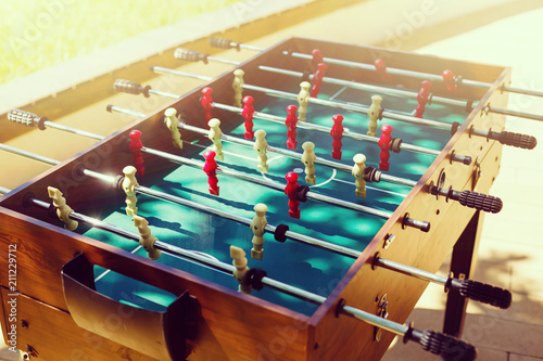 Cropped image playing foosball while resting outdoors photo