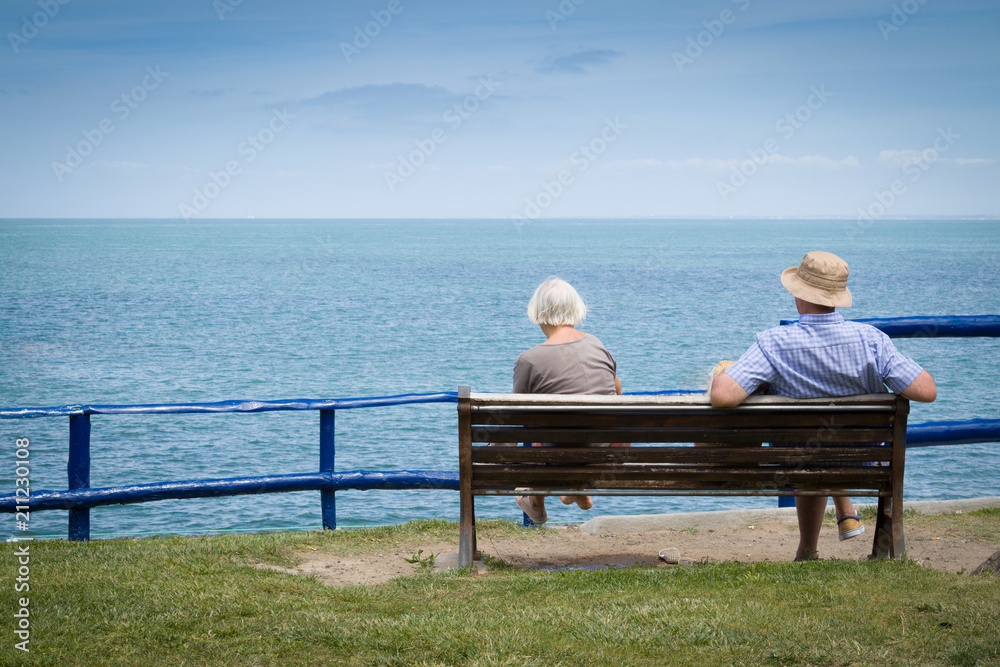 Elderly couple relaxing in front of the sea view. With copyspace above. Elderly couple relaxing in front of the sea view. With copyspace above.