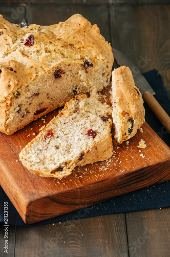 Irish soda bread with cranberries and raisins on wooden board. Close up.