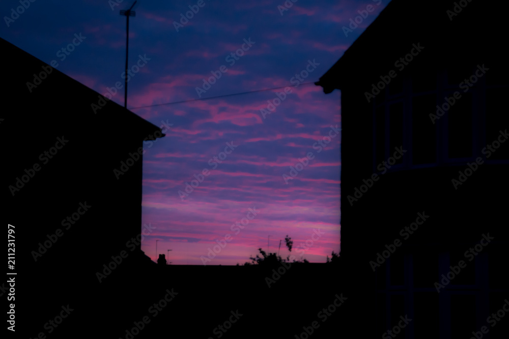 Night time view of house exterior of terraced houses on a street Night time view of house exterior of terraced houses on a street