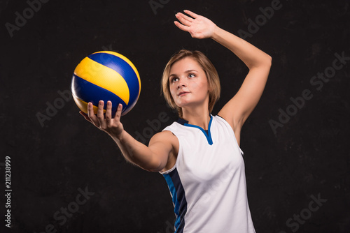 Girl playing volleyball on a dark background