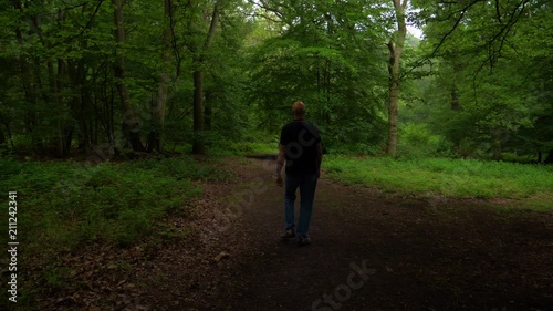 Clip of a man walking into a wood in the countryside photo