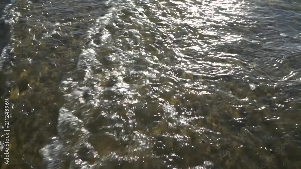 A lone man walking barefoot through the waves on the beach. Caspian Sea. Slow Motion. A lone man walking barefoot through the waves on the beach. Caspian Sea. Slow Motion.