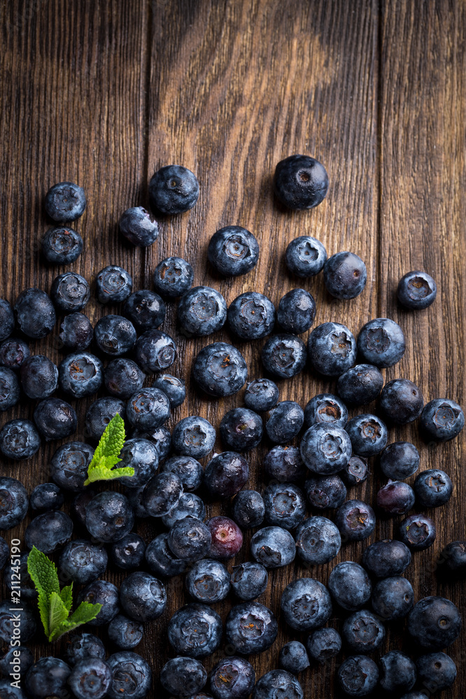 Fresh blueberries with mint on rustic wooden background, overhead view Fresh blueberries with mint on rustic wooden background, overhead view