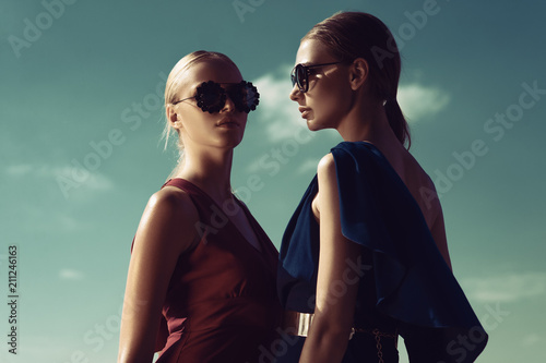 Two fashion models pose against the background of the Sunny sky