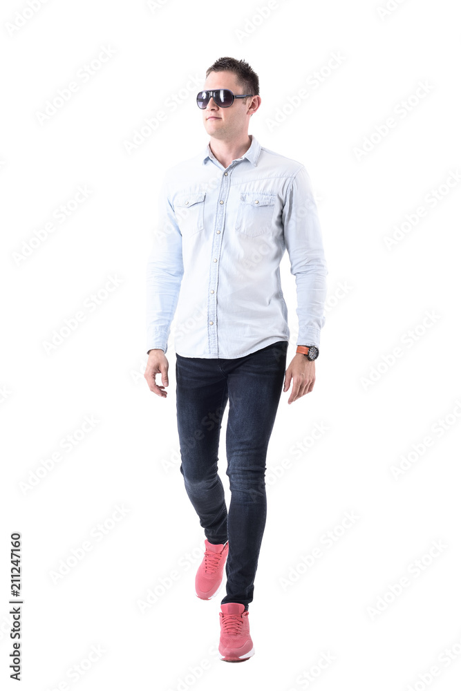 Front view of stylish elegant business man in pink sneakers with sunglasses walking and looking away. Full body isolated on white background. Front view of stylish elegant business man in pink sneakers with sunglasses walking and looking away. Full body isolated on white background.