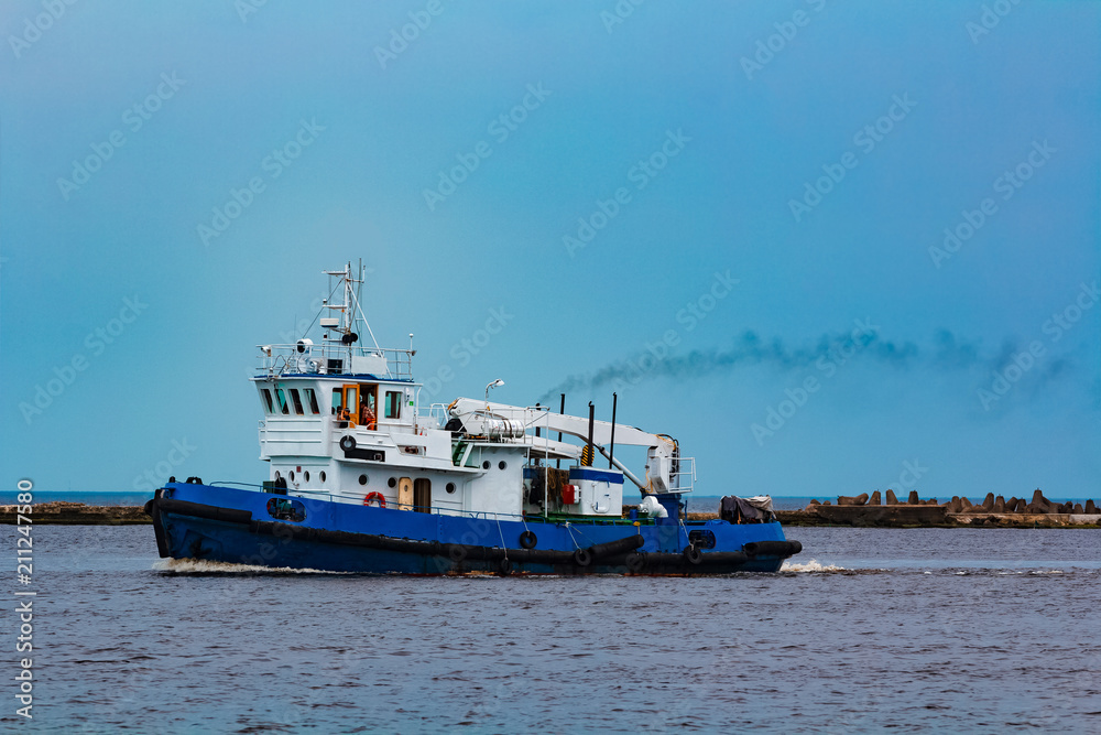 Blue tug ship underway