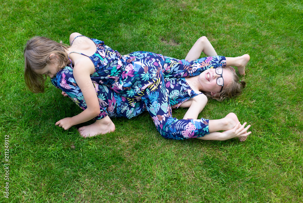 two sister on the grass playing and having fun two sister on the grass playing and having fun
