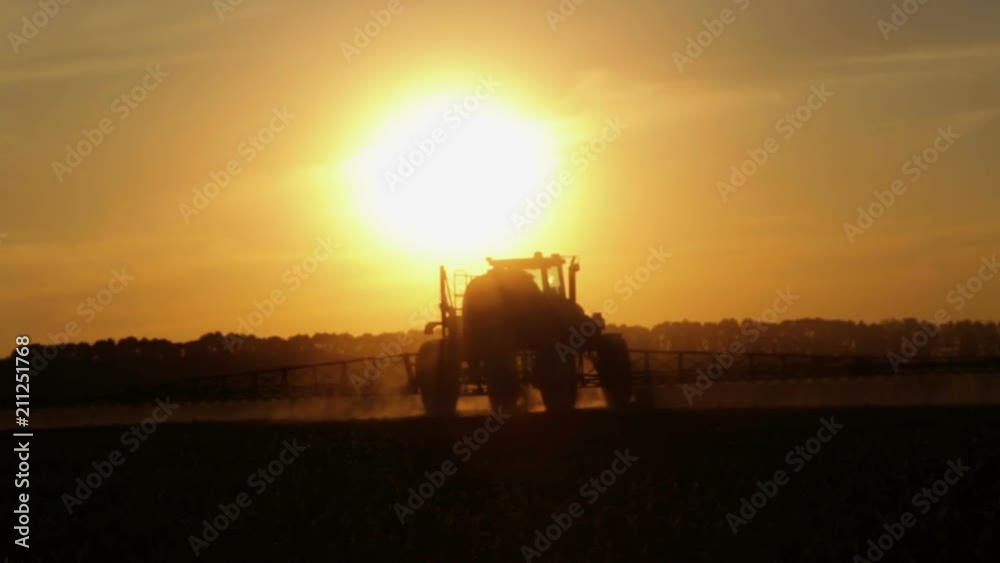 Tractor spraying chemicals in a field at sunset. Fertilizer application in the field of corn at sunset of the day.
Tractor spraying chemicals in a field at sunset. Fertilizer application in the field of corn at sunset of the day.