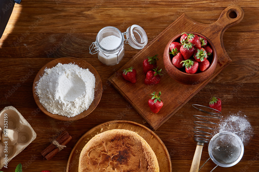 Delicious cake with fresh organic strawberries on cutting board over wooden background, close-up, selctive focus. Delicious cake with fresh organic strawberries on cutting board over wooden background, close-up, selctive focus.
