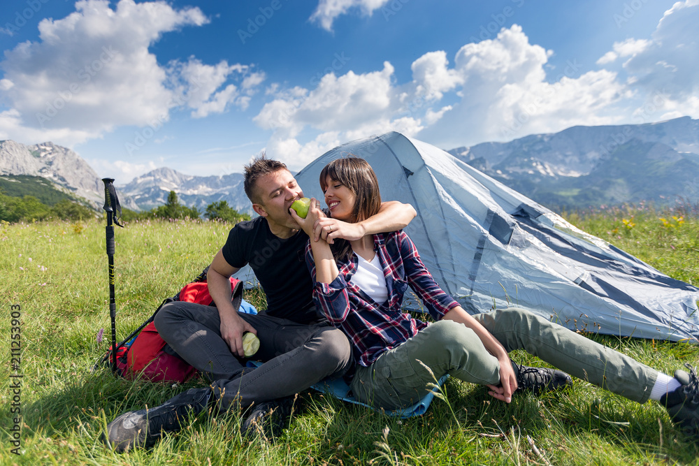 Couple enjoying at camping.Hikers eating apple at mountain near the tent
