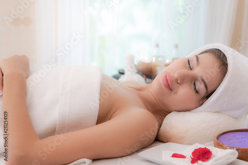 Beautiful woman lying down on the bed relax in spa salon with massage.