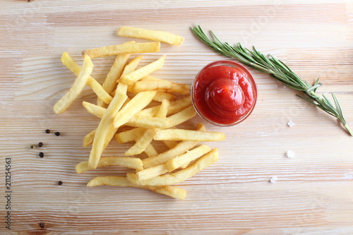 french fries and ketchup on a light wood background