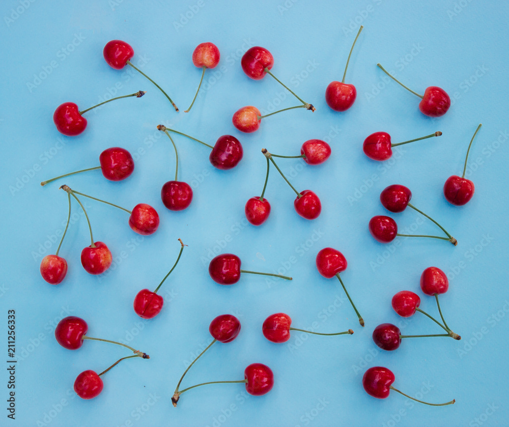 Red cherries on a blue background - summer background Red cherries on a blue background - summer background