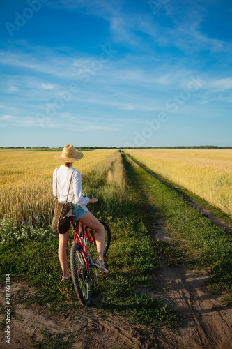 Fototapeta Naklejka Na Ścianę i Meble -  Woman on bike and beautiful countryside
