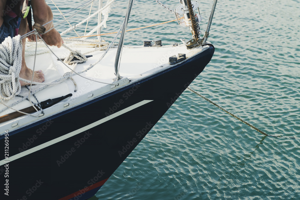Fototapeta premium man pulls the cables to anchor the yacht in the port