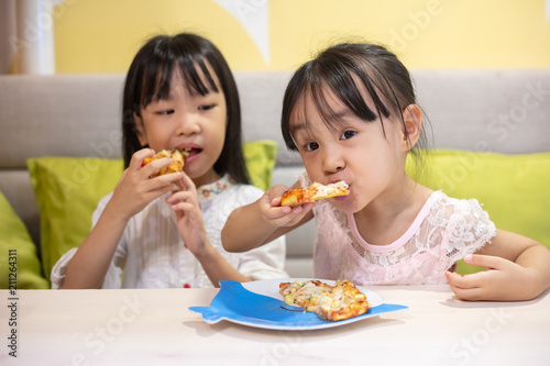 Asian Little Chinese sisters Eating pizza
