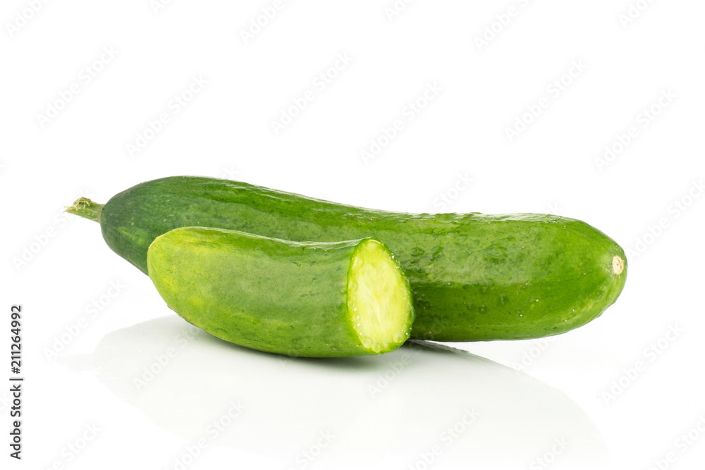 One fresh green mini cucumber with a half isolated on white background. One fresh green mini cucumber with a half isolated on white background.