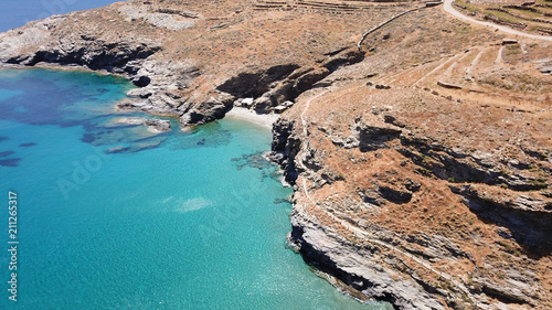 Aerial drone bird's eye view of iconic beach of Grias Pidima with giant rock rare geological formation and turquoise crystal clear waters, near village of Korthi, Andros island, Cyclades, Greece