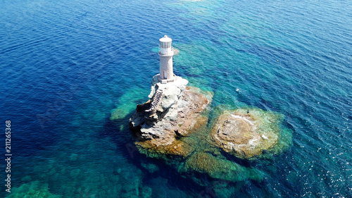 Aerial drone bird's eye view of iconic lighthouse of Tourlitis in port of Andros island chora, Cyclades, Greece