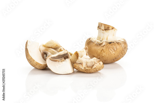 Sliced brown champignons one whole and three slices isolated on white background fresh raw mushrooms.